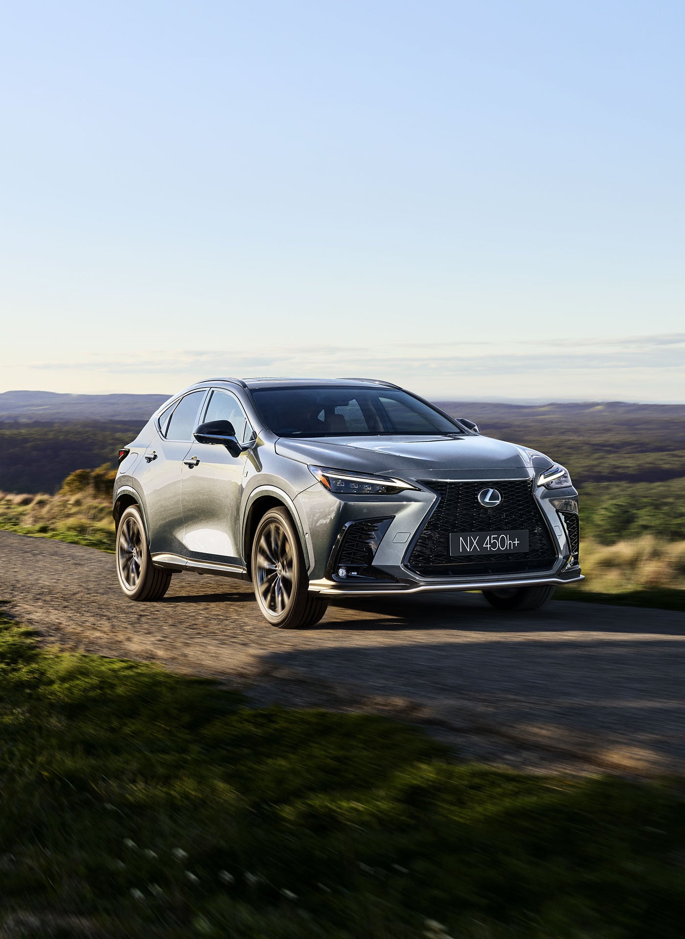 Lexus NX 450h+ driving along a country road
