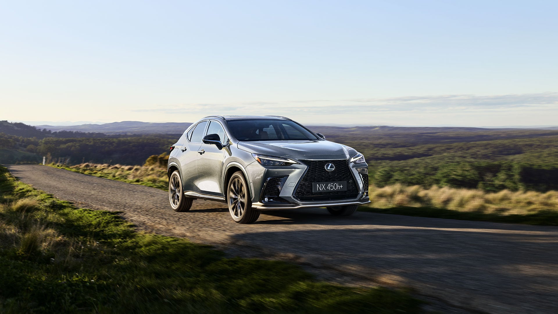 Lexus NX 450h+ driving along a country road